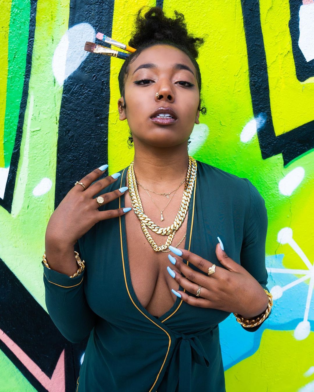 beautiful model wears two miami gold cuban link chains and gold cuban link bracelets by gusvilla jewelry