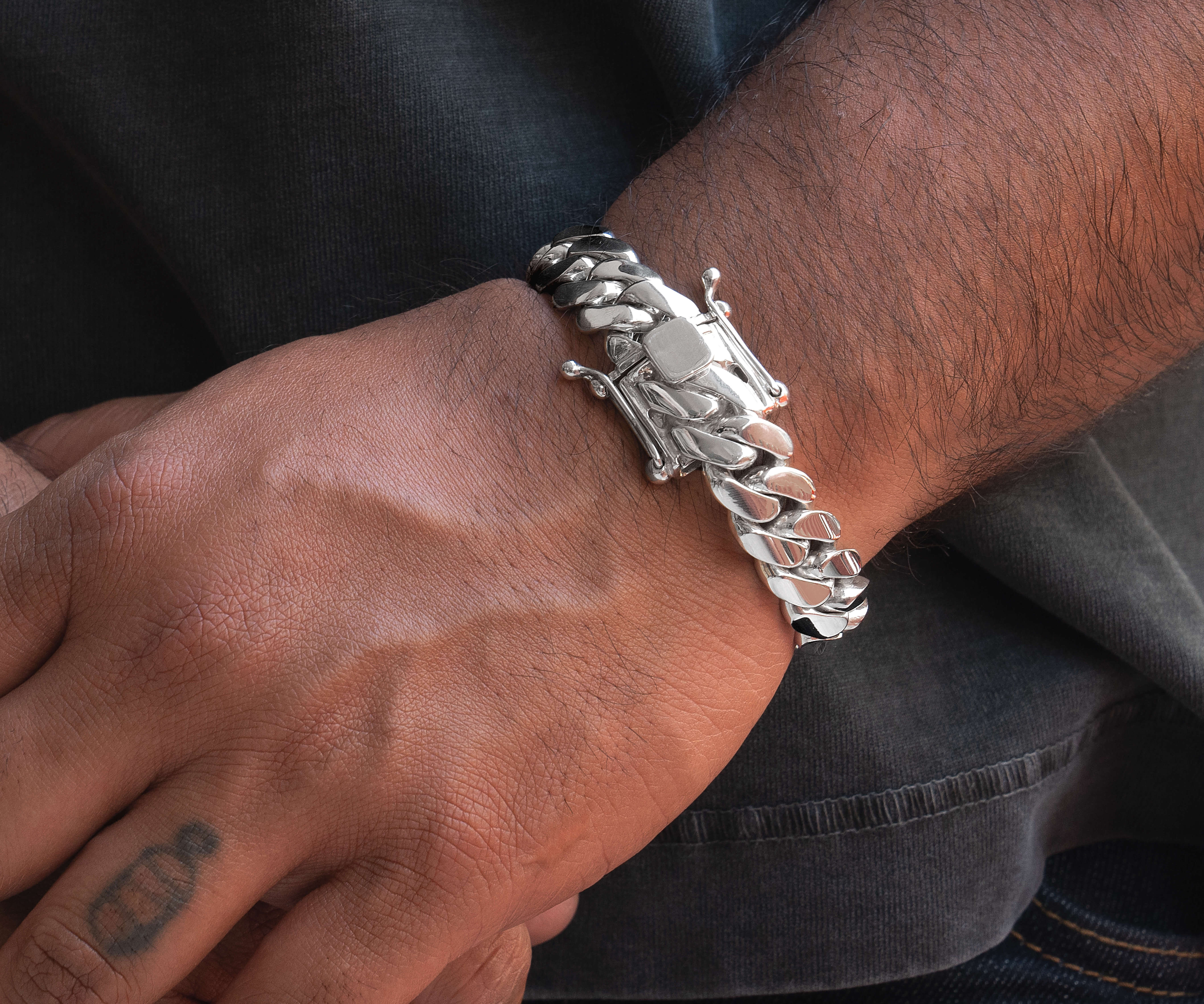 man wearing 14 mm silver cuban link bracelet